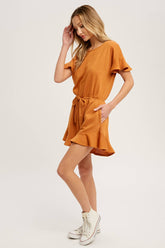 Soft French terry romper with ruffled sleeves, elastic waist, pockets & back button closure. Comfy, cute, and perfect for sunny days or casual outings.