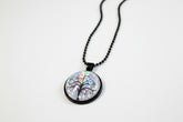 Handcrafted nature scene necklaces with real botanicals in iridescent and clear resin. Unique, wearable landscapes on chain or satin cord.