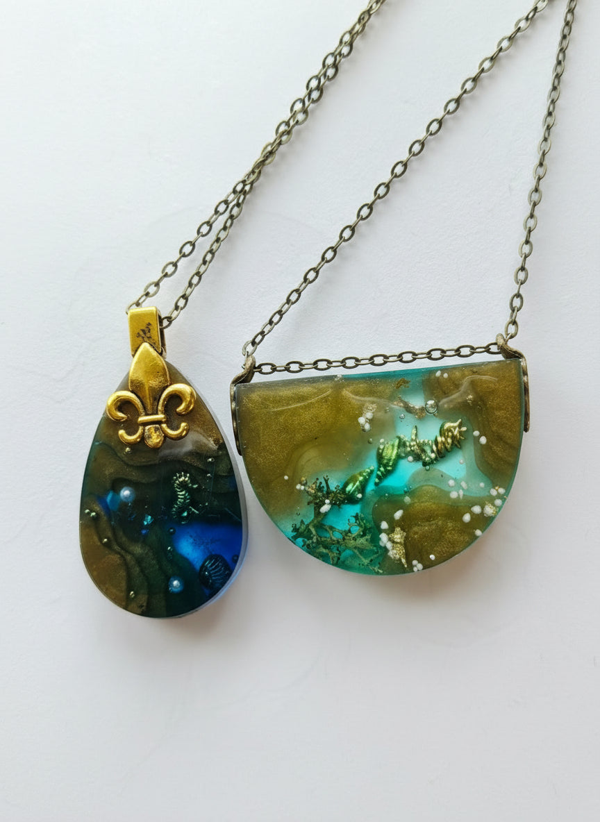 Sea Life Resin Pendant Necklaces by artist KStonely featuring shells, fish, jellyfish, and sea life miniatures in dreamy blue, brown, and gold ocean-inspired resin.