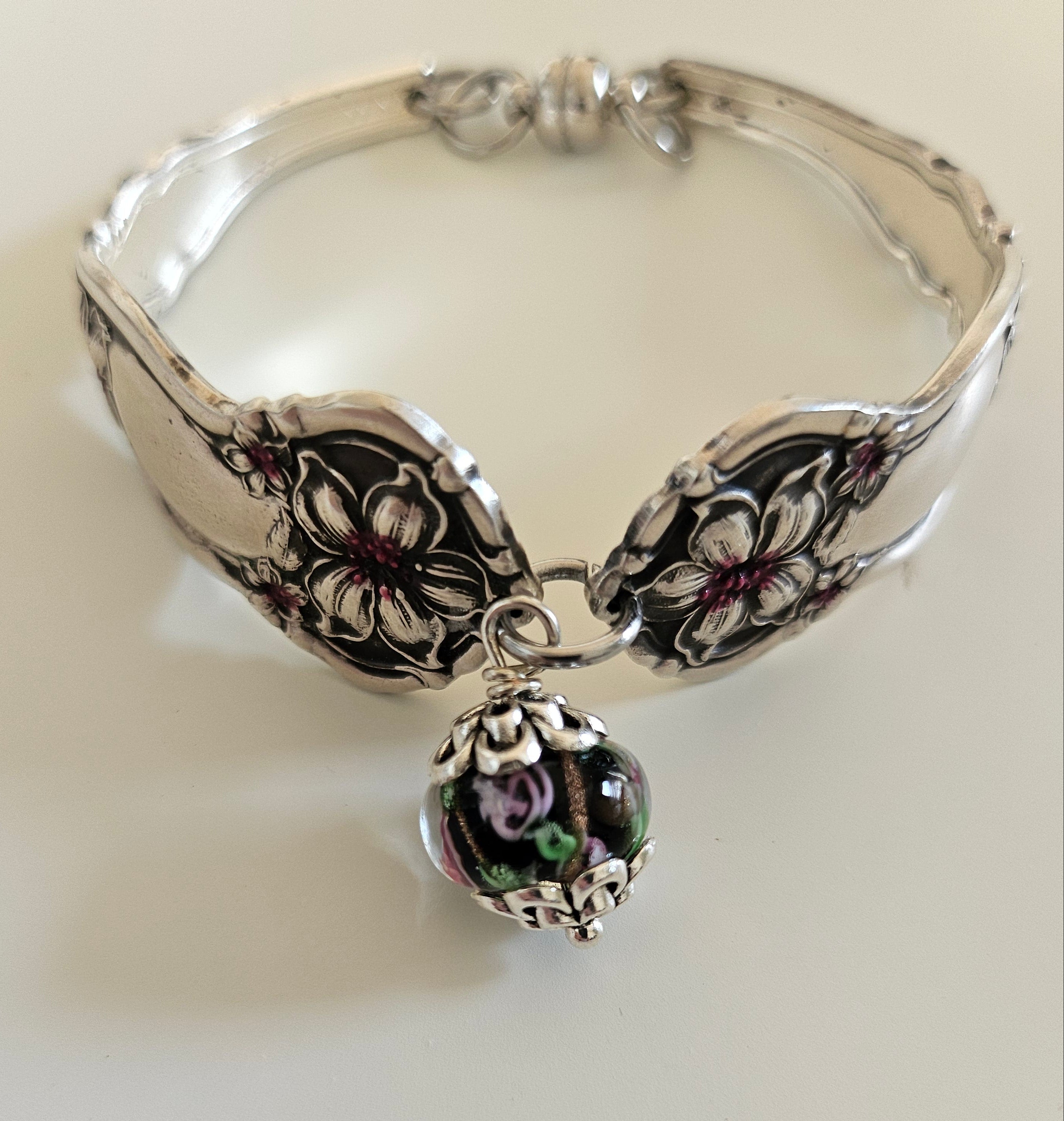 Handcrafted from 1910 Wm. Rogers silverware, this vintage Orange Blossom bracelet features glass beads, a magnetic clasp, and timeless floral charm.