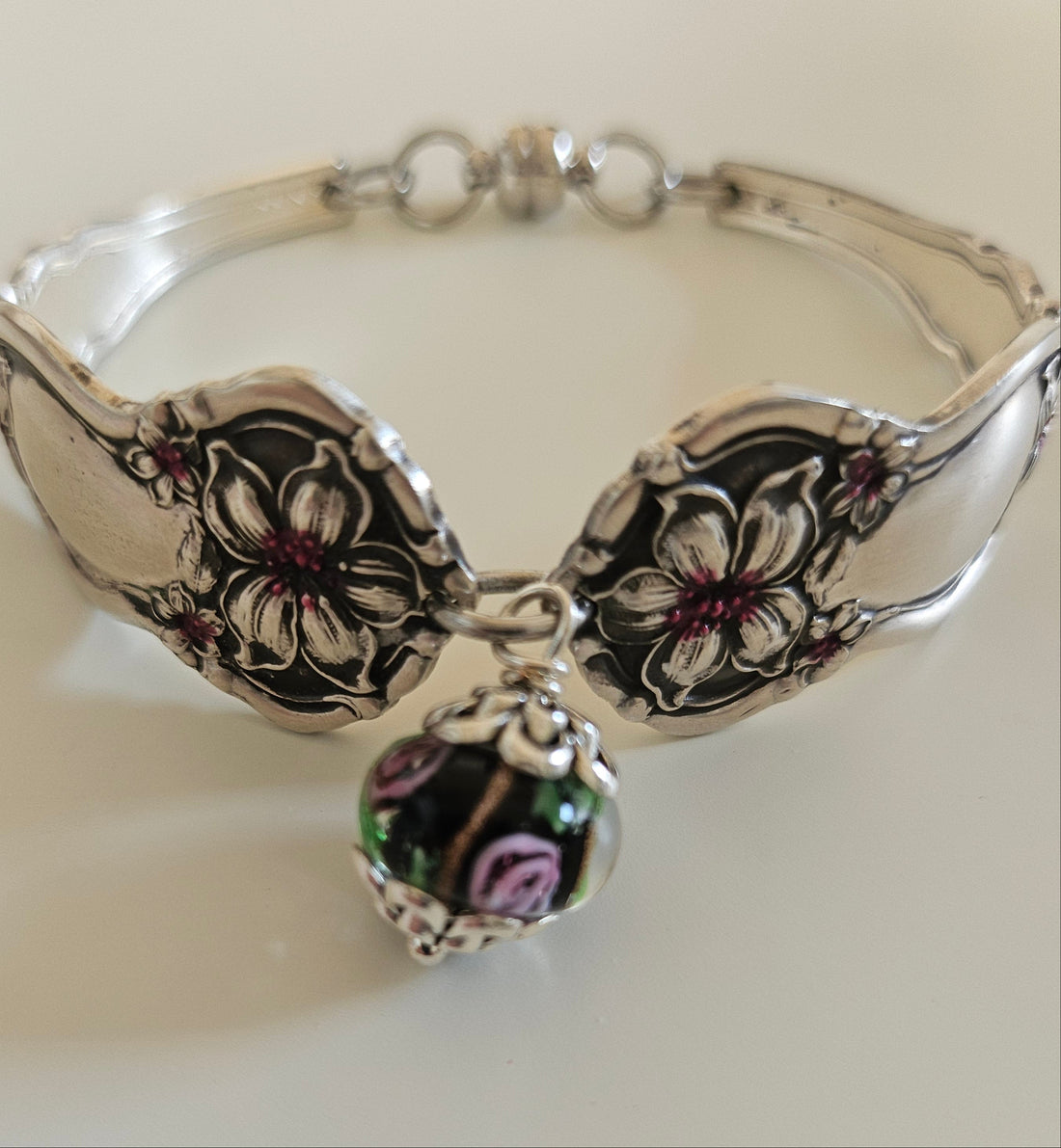 Handcrafted from 1910 Wm. Rogers silverware, this vintage Orange Blossom bracelet features glass beads, a magnetic clasp, and timeless floral charm.