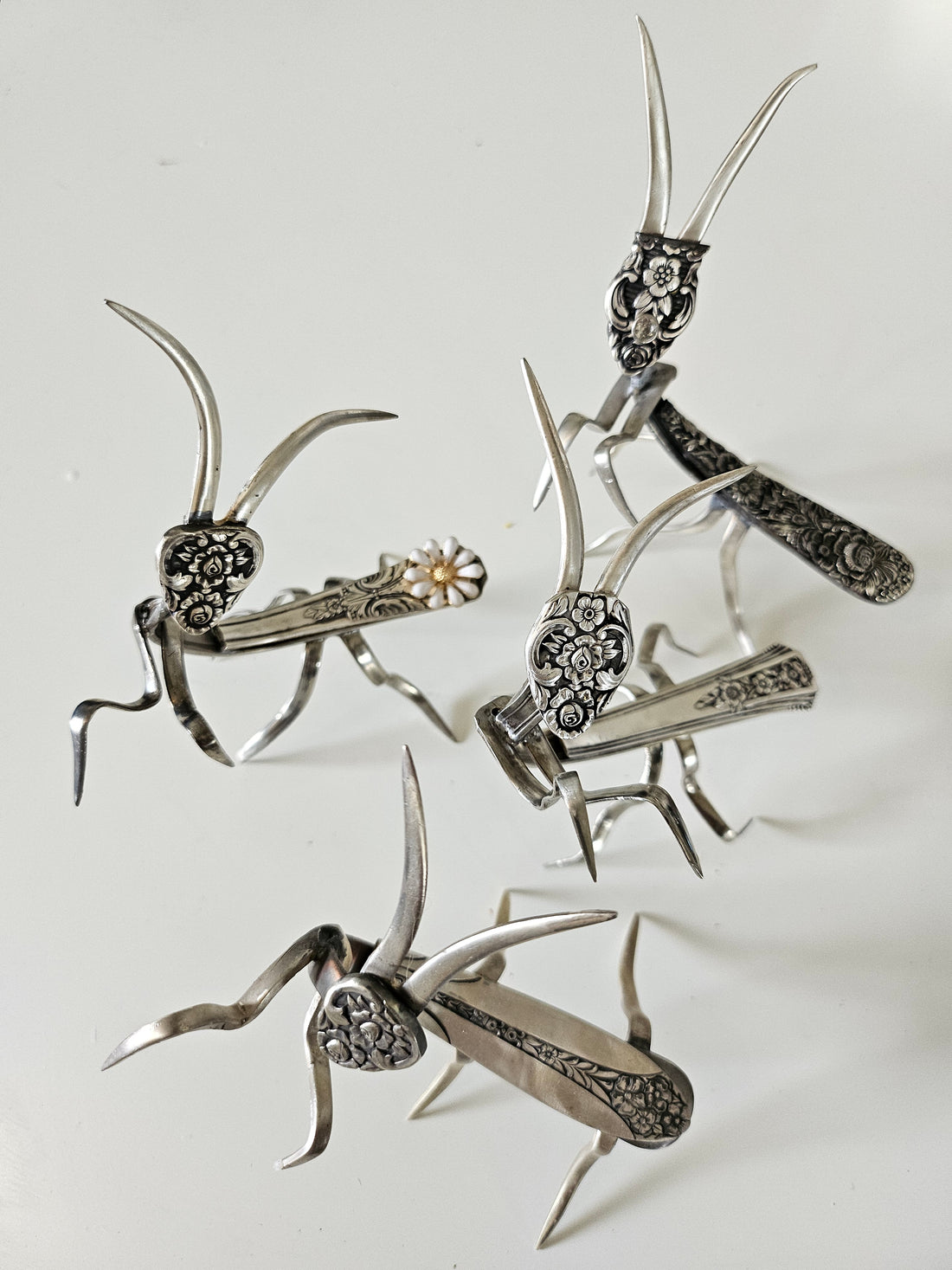 Handcrafted 5" x 4" praying mantis sculpture made from vintage silverware. Unique, whimsical art with gemstone accents and aged patina for mindful décor.