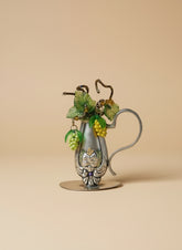 Vintage silverware bud vase with handcrafted beaded flowers by artist KStonely. Unique, eco-friendly cottagecore décor perfect for shelves, desks, and gifting.