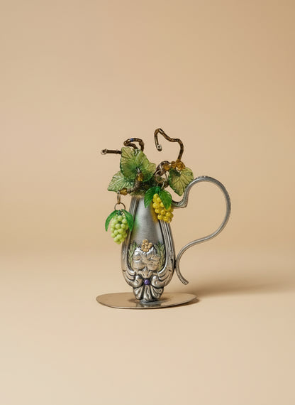 Vintage silverware bud vase with handcrafted beaded flowers by artist KStonely. Unique, eco-friendly cottagecore décor perfect for shelves, desks, and gifting.