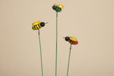 Whimsical bee plant picks with wooden bees on springs. Adds playful movement to houseplants and gardens. Adjustable 19" stake. No plants included.