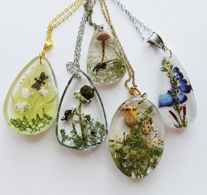 Gathered-in-the-Wild Botanical Necklace with real foraged flowers, mushrooms, pine needles, and leaves preserved in resin. Handcrafted wearable nature art by KStonely.