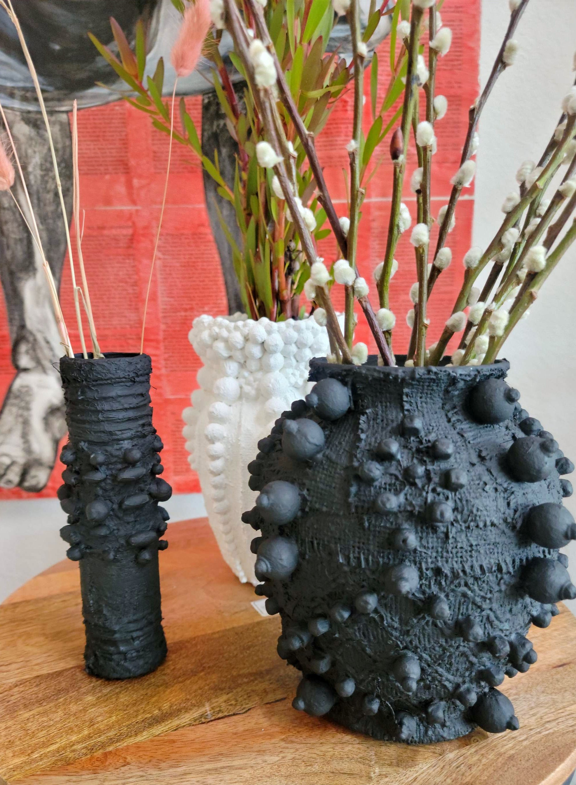 Elevate your decor with this handcrafted upcycled glass urn-shaped vase, made from reclaimed materials for a sustainable touch. Available in Glossy Black or Matte White, each unique piece offers artistic flair and eco-friendly style. Perfect for fresh or dried flowers, it suits both indoor and covered outdoor spaces.