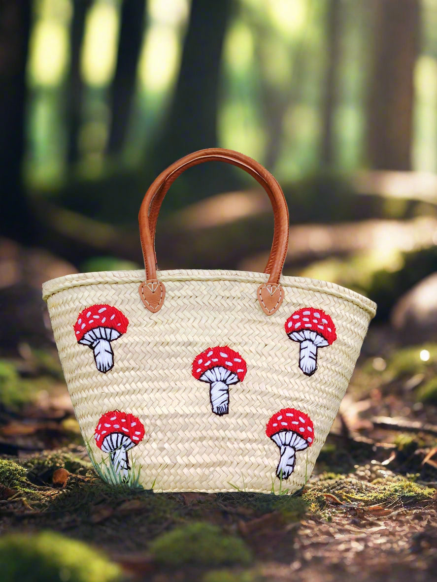 Whimsical straw tote with red mushroom embroidery, leather handles &amp; eco-friendly palm straw. Perfect for market trips, beach days, or unique gifting.