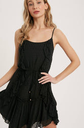 Swiss dot mini dress with ruffle details, lace-up back, adjustable straps & waist tie. Lightweight rayon, perfect for warm days & effortlessly chic looks.
