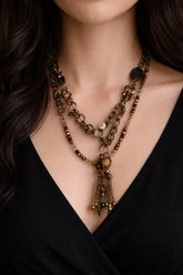 Layered antique-style chains with earthy beads and a charm tassel. The Nomad Layer Necklace is a soulful, wander-inspired statement.