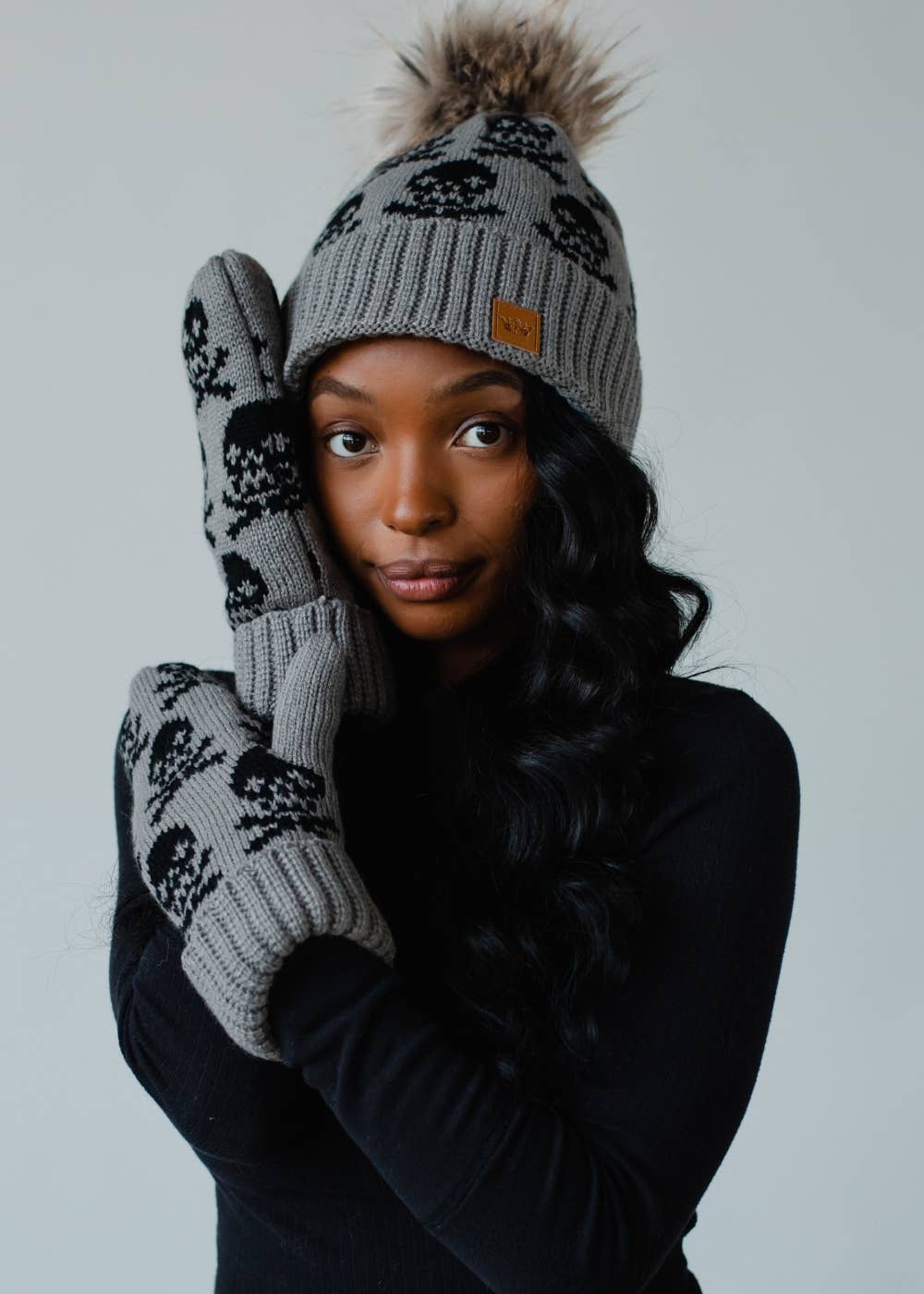 Gray skull patterned knit mittens with cozy fleece lining. Made from 100% acrylic for warmth and comfort. A bold, stylish essential for cold winter days.